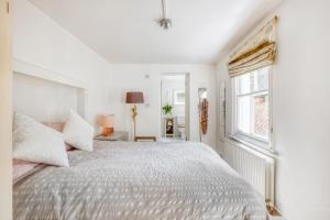 伦敦Pass the Keys - Beautiful stylish flat in South West London的白色的卧室设有一张大床和一个窗户