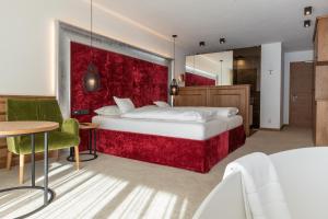 圣克里斯蒂娜Diamant Spa Resort的一间卧室设有一张红色墙壁的大床