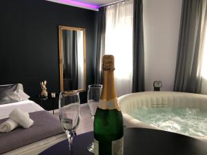 萨格勒布Apartment Zagreb Jacuzzi的浴缸旁的桌子上摆放着一瓶香槟