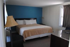 波因特普莱森特海滩岸点汽车旅馆 的酒店客房,设有床铺和蓝色的墙壁