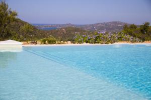 奥尔比亚Casagliana Suite Resort的海滩旁的蓝色海水游泳池