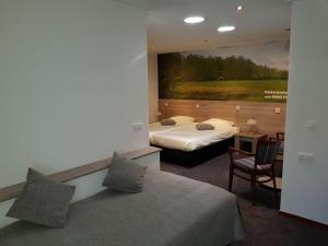 奥尔登扎尔赫特兰德胡伊斯酒店的酒店客房设有两张床,墙上挂有绘画作品