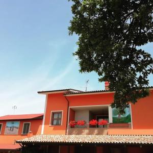 阿布鲁齐的罗塞托B&B Gli amici del tubarello的阳台上的橙色房子,种着红色的鲜花