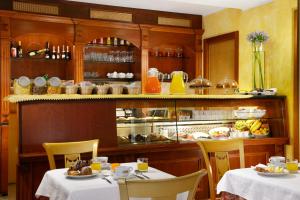 罗马图索拉纳酒店的餐厅设有两张桌子,提供自助餐和食物
