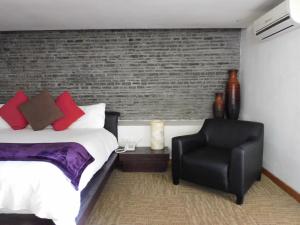阿特利斯科Hotel & Spa Luna Canela Boutique的一间卧室配有一张床和一张黑椅