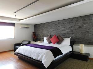 阿特利斯科Hotel & Spa Luna Canela Boutique的一间卧室设有一张大床和砖墙