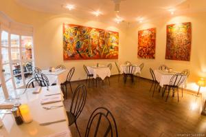 麦德林61Prado Hotel的一间带桌椅和绘画的用餐室