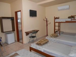 博尼图Pousada Paraiso的客房设有两张双层床和一张书桌。