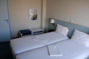 卡罗维西阿斯蒂尔酒店 的一间卧室配有两张带蓝色床头板的床