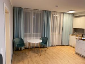 纽伦堡City Studio-Apartment am Hauptbahnhof N6的一间设有桌子和两把椅子的房间和一间厨房