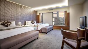 台中市中科大饭店的酒店客房设有两张床和电视。
