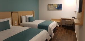 韦拉克鲁斯Hotel Plaza Sol Veracruz的酒店客房配有两张床和一张书桌