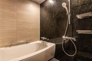 东京Tokyo Bay Shiomi Prince Hotel的设有带浴缸和淋浴的浴室。
