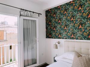 塞维利亚Boutike Guesthouse的卧室的墙上装饰有花卉图案的壁纸
