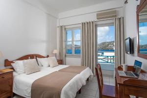 伊奥斯乔拉艾克缇昂酒店的酒店客房设有一张床、一张书桌和窗户。
