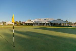 贝里Big River Golf & Country Club的一座高尔夫球场,在一座建筑前有一个黄色的旗帜