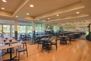 贝里Big River Golf & Country Club的餐厅设有桌椅和窗户。