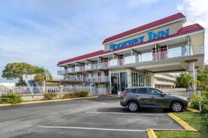 克利尔沃特Rodeway Inn Clearwater-Largo的停在酒店前停车场的汽车