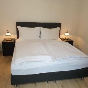 布拉格布拉格坎帕格雷格公寓的一张带白色床单的大床和2个床头柜