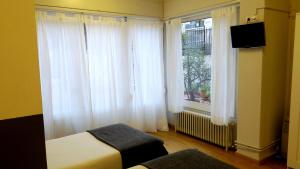 巴塞罗那埃拉尼诺旅馆的卧室配有白色窗帘、床和窗户