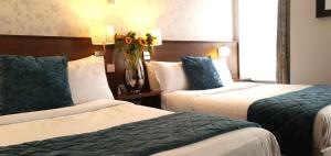 都柏林The Gate Hotel的酒店客房带两张床和花瓶