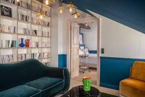 巴黎Chouchou Hotel的客厅设有绿色沙发和书架