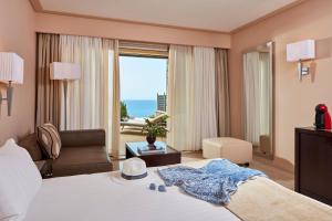 KompítsionAtlantica Grand Mediterraneo Resort - Adults Only的酒店客房设有一张床,享有海景。