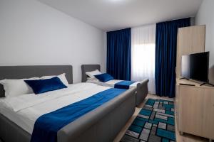 布加勒斯特Hotel Simona的一间卧室配有一张大床和电视