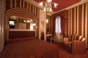 威尼斯阿尔雄酒店的一间卧室配有一张床、一把椅子和镜子