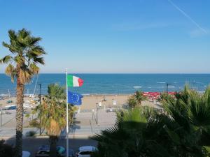 葛伦坦马勒Residence Le Palme的一片拥有旗帜和棕榈树的海滩和大海