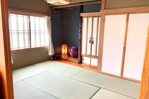 白老町Manyi's Onsen House 天然温泉マンイの湯的一间空房间,带窗户,还有一间房间,带灯