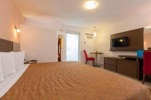 巴亚尔塔港Crown Paradise Club All Inclusive的酒店客房设有一张大床和一张书桌。
