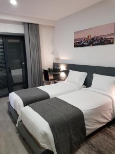布拉干萨O Abel Hotel rural的酒店客房配有两张床和一张书桌