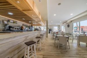 科尼尔-德拉弗龙特拉Glamping -Bungalows El Faro的餐厅设有酒吧和桌椅