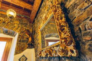 的里雅斯特AQUILA D'ORO TRIESTE的挂在石墙上的金色镜子