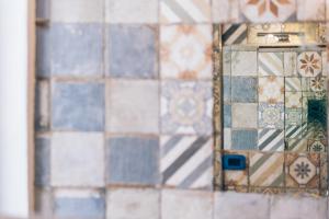 的里雅斯特AQUILA D'ORO TRIESTE的镜子中的瓷砖墙反射