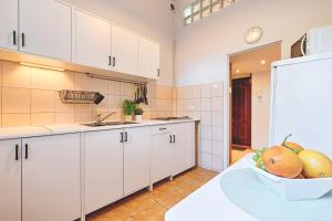 罗兹deLux3的厨房配有白色橱柜和一碗水果