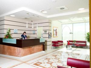 莫夏诺圣安杰洛冲刺商务酒店的站在医院大厅柜台的女人