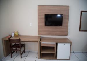 阿拉沙Hotel Dona Beja的客房设有书桌和墙上的电视