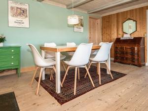 森讷维6 person holiday home in Ringk bing的一间带桌子和白色椅子的用餐室