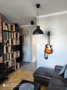 卢布林Apartament przy Zamku的客厅配有挂在墙上的吉他