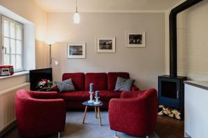 伊尔梅瑙Ferienwohnung VILLA FRÜBING的客厅配有红色的沙发和两把椅子