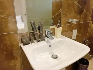 内罗毕La Maison Royale South C的浴室设有白色水槽和镜子