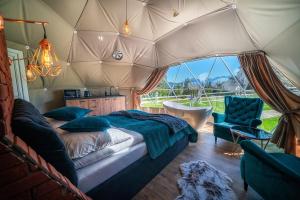 扎科帕内Mountain Glamp & Gorąca Balia的帐篷内的卧室,配有一张床和椅子