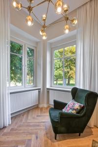 奥西耶克Apartman Otokar的客厅设有绿色椅子和窗户