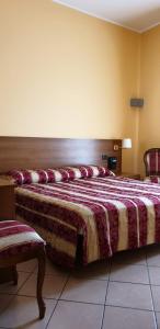 兰达佐Hotel Scrivano的一间卧室配有一张大床和两把椅子