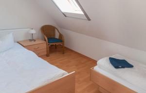 普劳西Ferienhaus Plau am See, direkt am Wasser的一间卧室设有两张床、一把椅子和一个窗户。