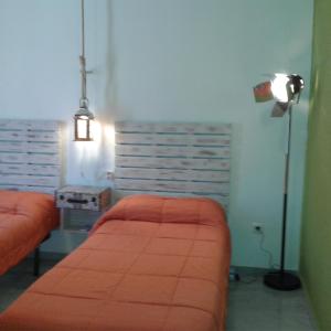 格拉纳达格拉纳达旧城区旅馆的一间卧室配有两张橙色的床和一盏灯