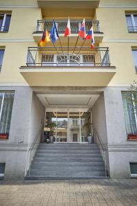 弗兰季谢克矿泉镇布鲁塞尔酒店的阳台上有三面旗帜的建筑