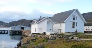 Kongsfjord洛夫森博格布里吉度假屋的水体旁的白色房子